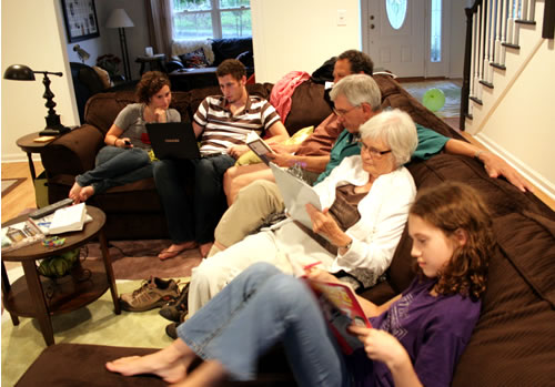 family on sofa doing digital activities